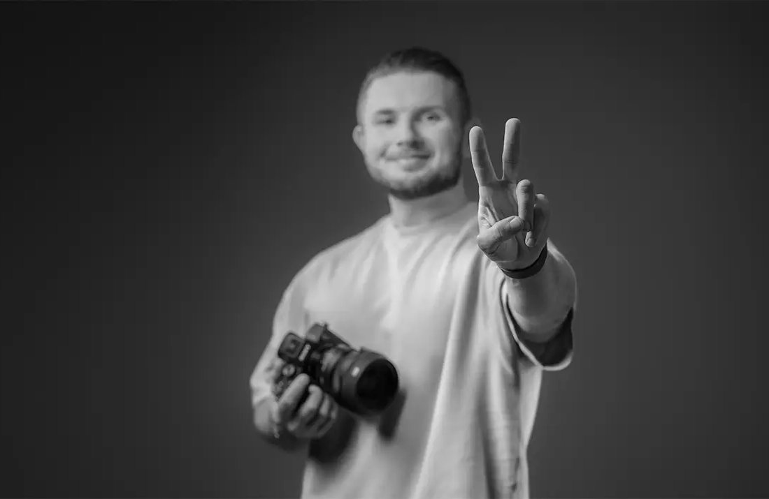Artur Schütz, Fotograf aus Troisdorf, mit Kamera und Peace-Zeichen